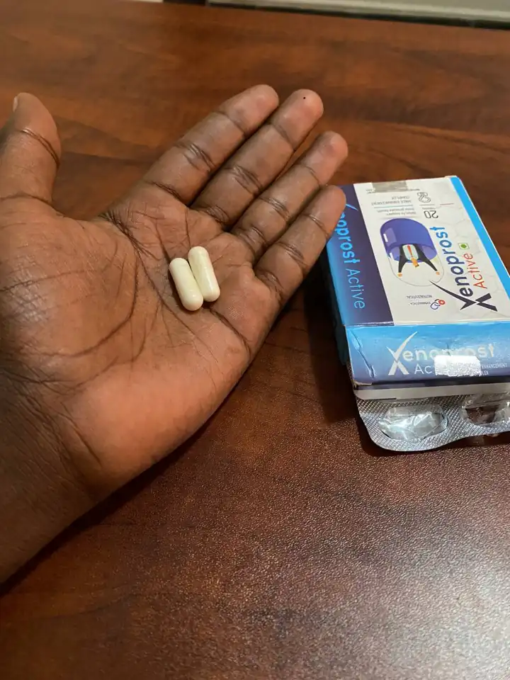 Two Xenoprost Active capsules on a palm with the box nearby